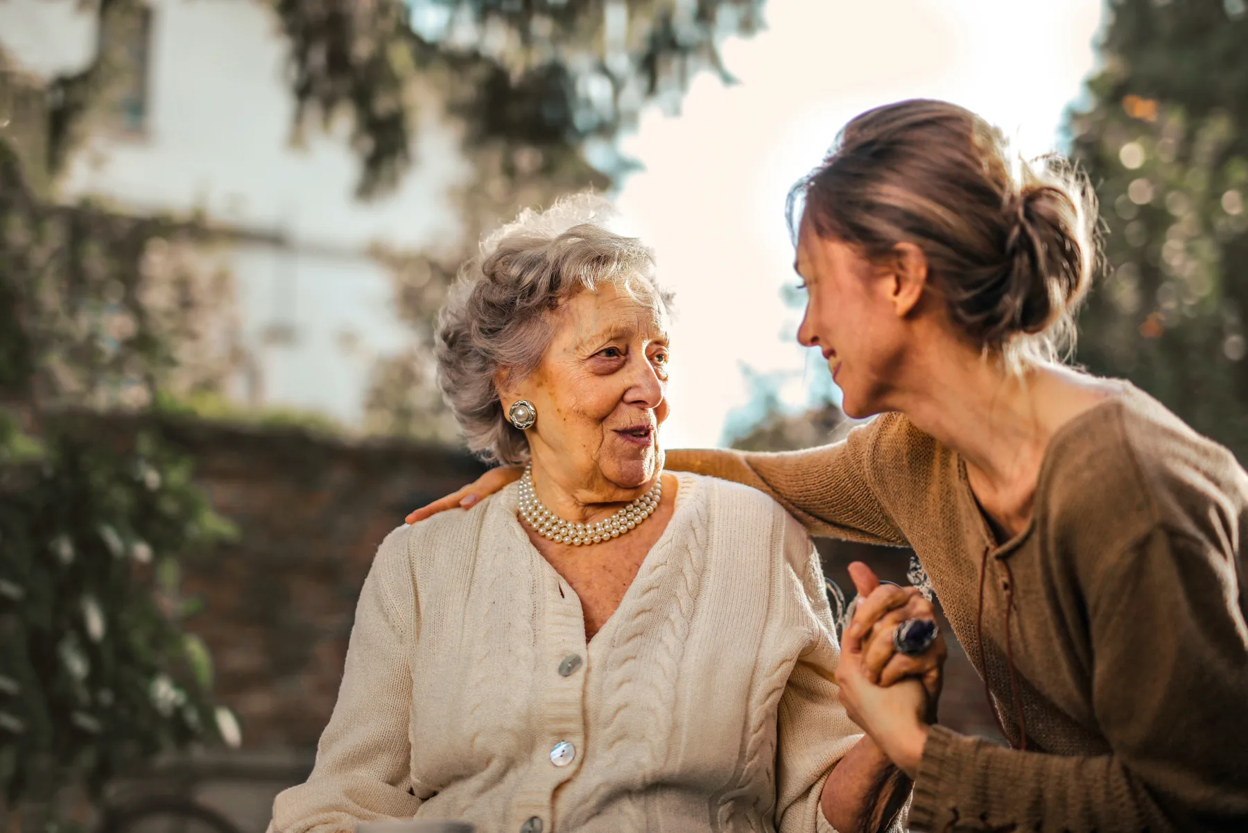 An adult daughter sharing a warm moment with her elderly mother