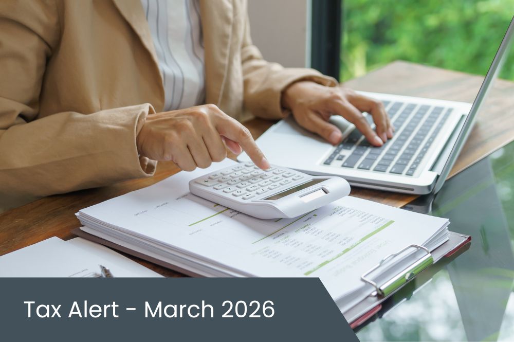 Tax Alert – March 2026 (3) Person doing taxes with calculator