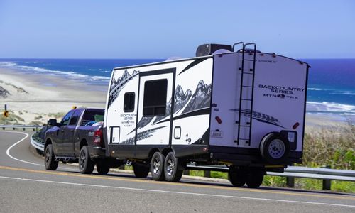 Ute towing caravan on ocean road