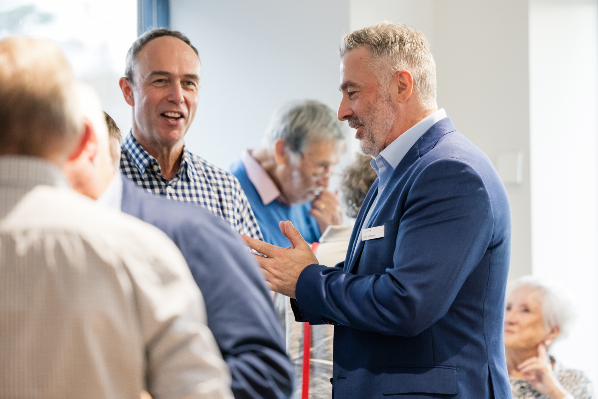 An adviser talking with guests at an Alteris Melbourne event