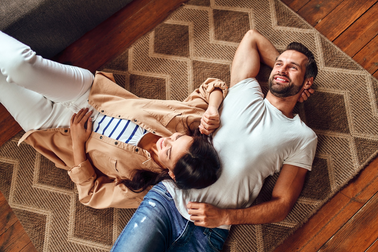 A couple relaxing together on a rug at home.