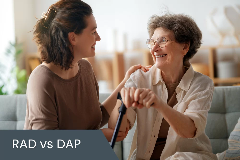 Elderly mother with her adult daughter sitting on couch